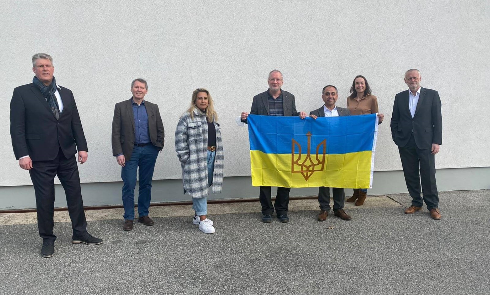 Dorfner Geschäftsführung steht in einer Reihe. Mehrere Personen halten Ukraine-Flagge in der Hand