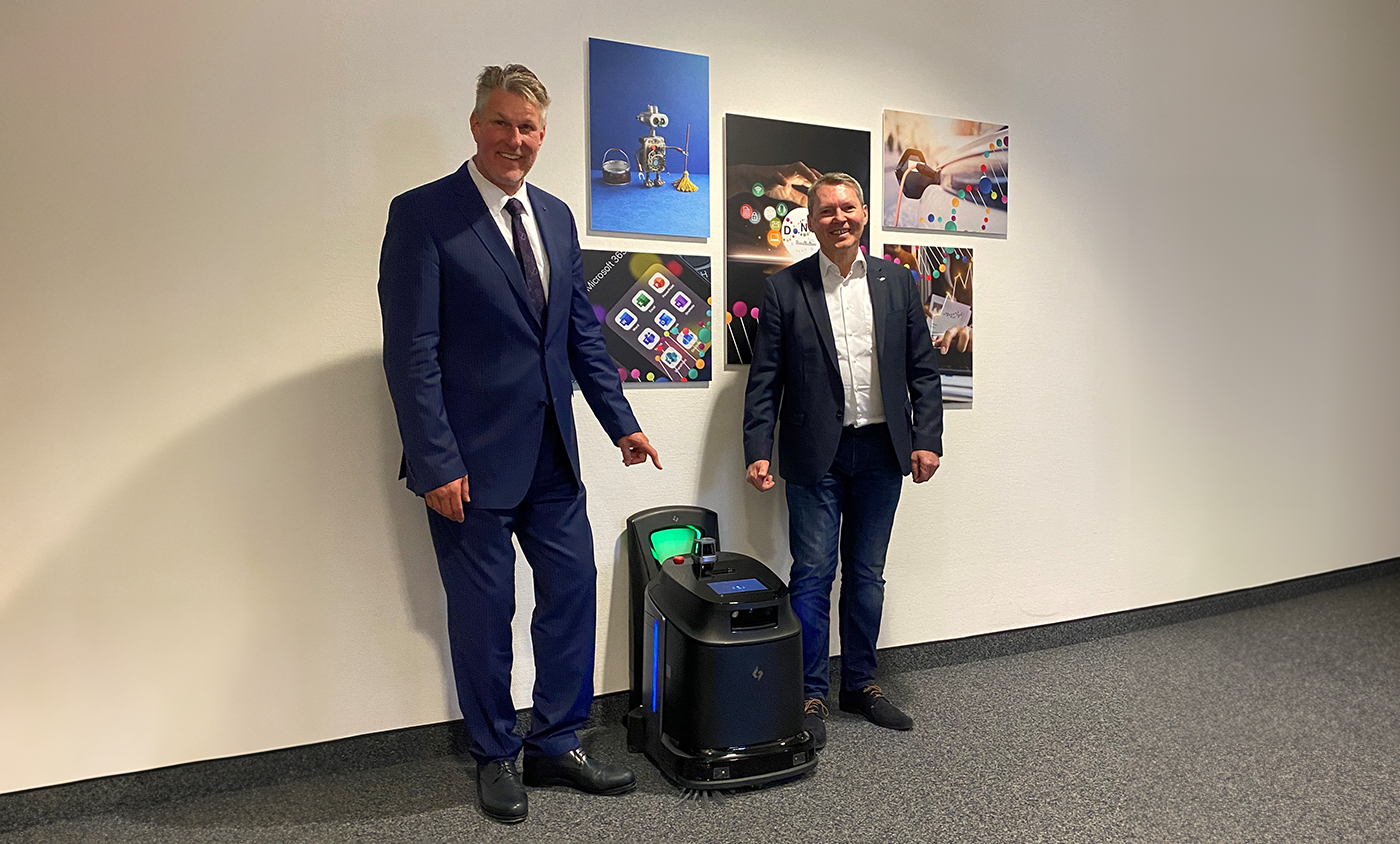 Geschäftsführer Peter Engelbrecht und Geschäftsleiter für Vertrieb und Marketing Thomas Hilger stehen neben einem Dorfner Reinigungsroboter